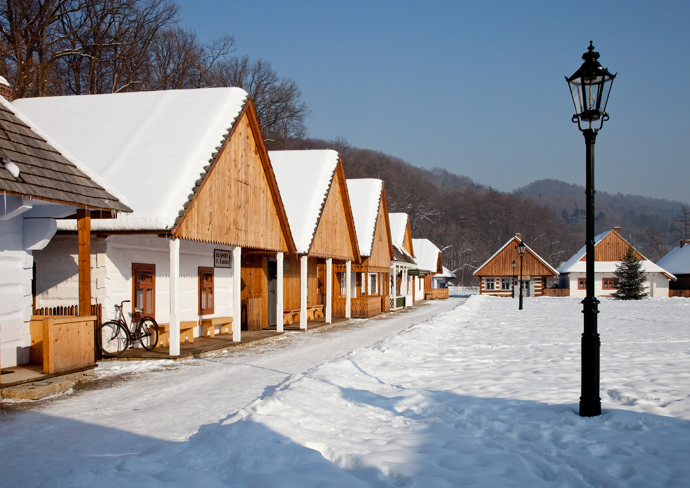 Zima. Rząd drewnianych budynków przy rynku