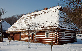 Zima. Drewniana chata przykryta warstwą śniegu
