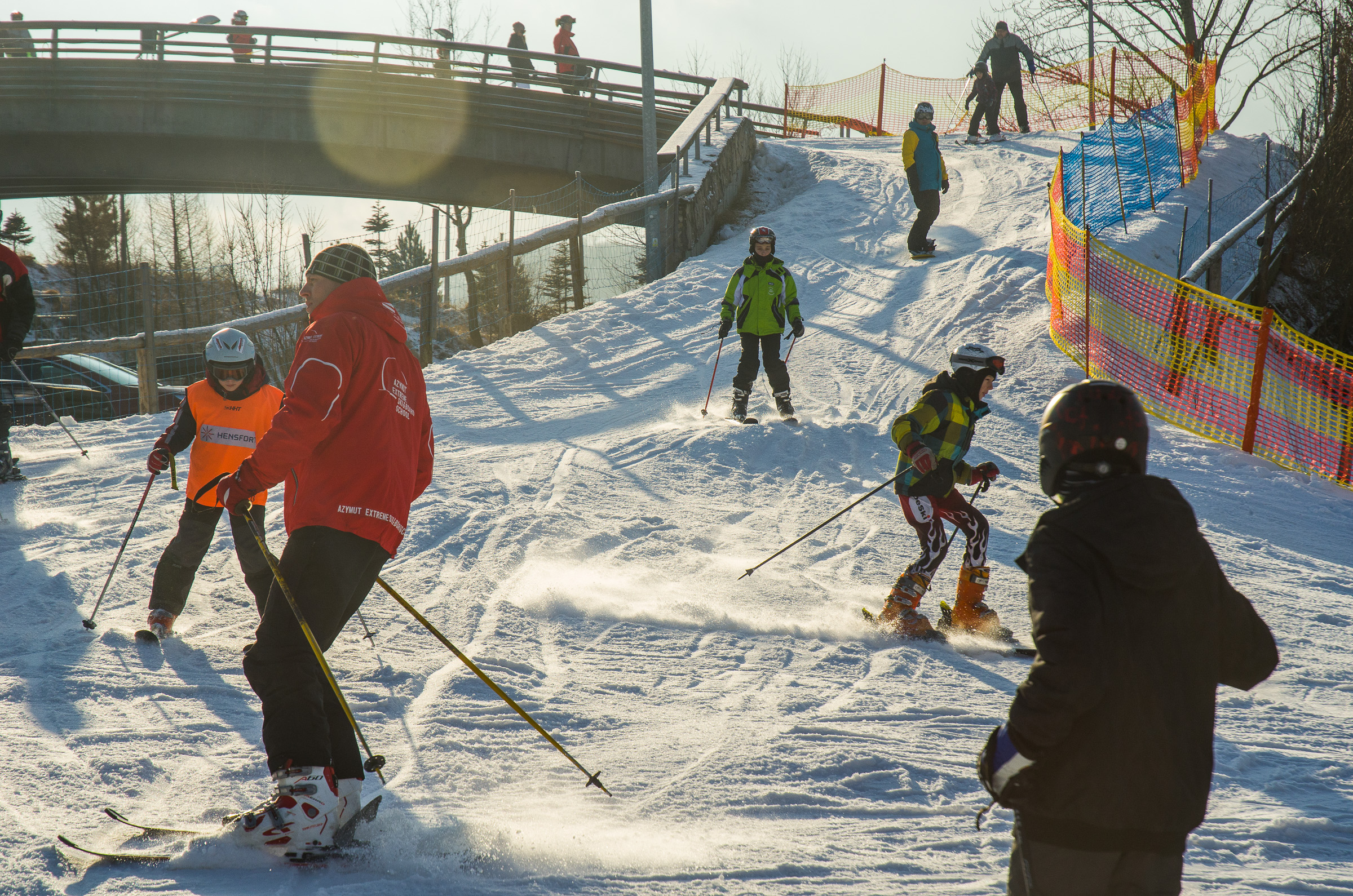 Zima grupa dzieci zjeżdżająca na nartach.