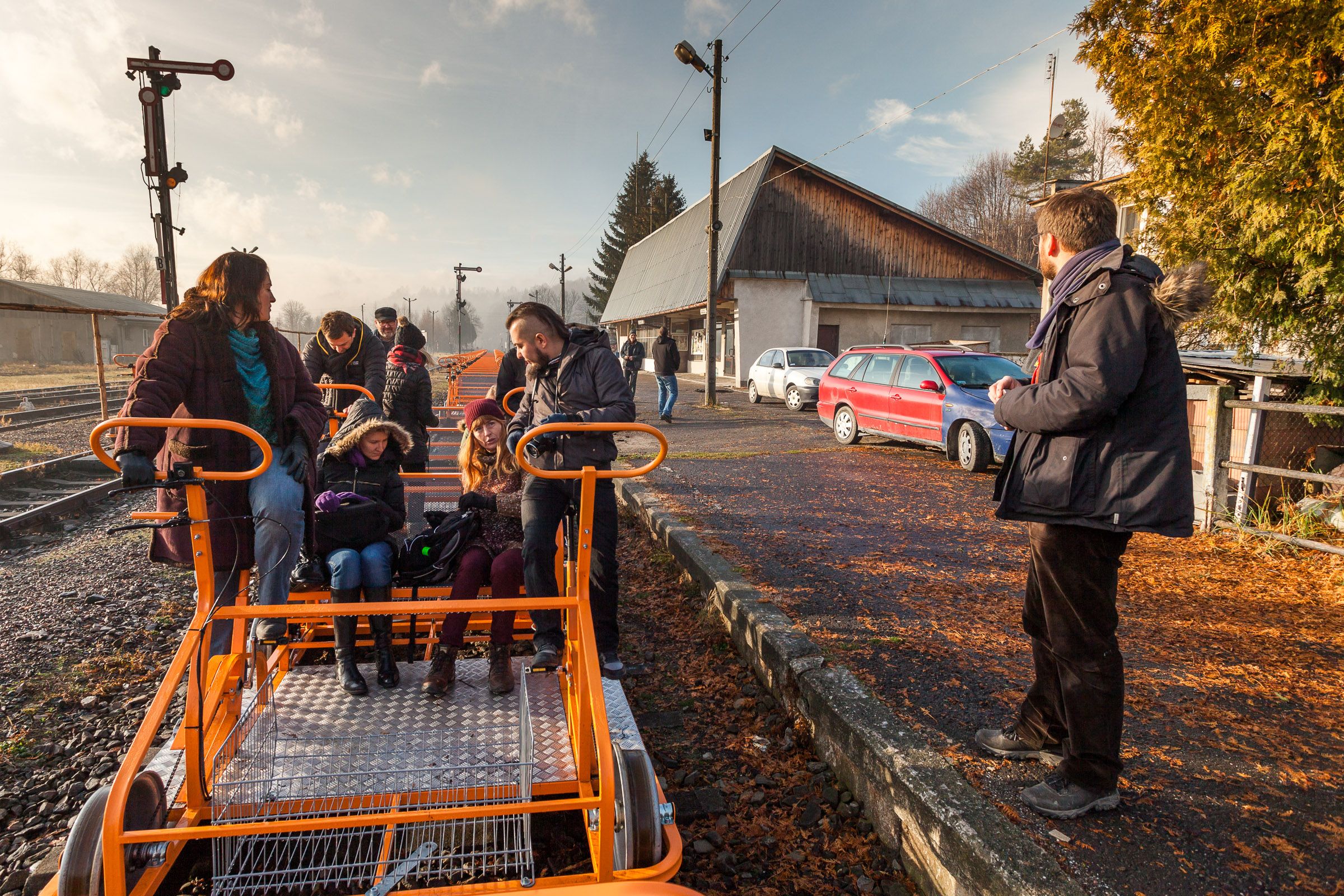 Turyści wchodzący do pomarańczowych drezyn rowerowych