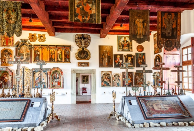 Ekspozycja muzealna. W dużej sali znajdują się cerkiewne drewniane krzyże oraz ikony.
