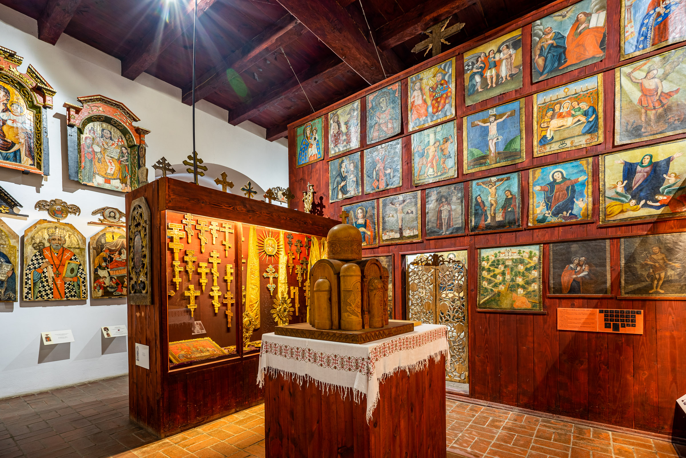 Sala wystawowa. Na ścianach powieszone ikony prawosławne. W gablotach drewniane krzyże