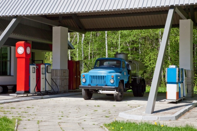 Muzeum w Bóbrce. Stara stacja benzynowa. Pod wiatą niebieska stara ciężarówka-cysterna i dystrybutory z paliwem.