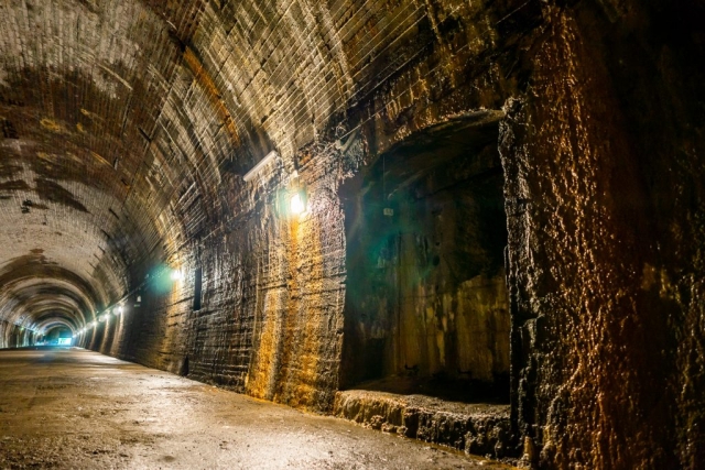 Żelbetonowa ściana tunelu. Łukowane ściany rozświetlają umieszczone co kilka metrów pojedyncze lampy.