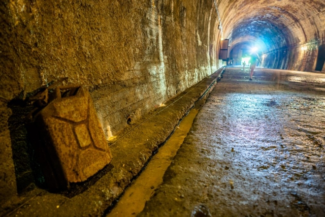 Detal. Żelbetonowa ściana tunelu. W tle wejście z którego dochodzi jasne światło