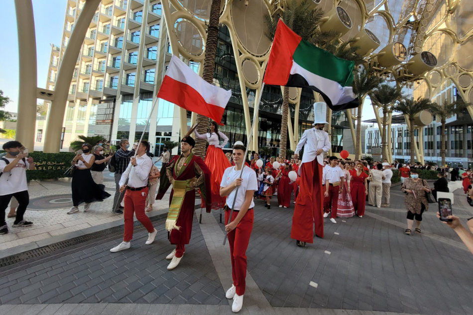 Parada grupy osób w biało-czerwonych strojach.