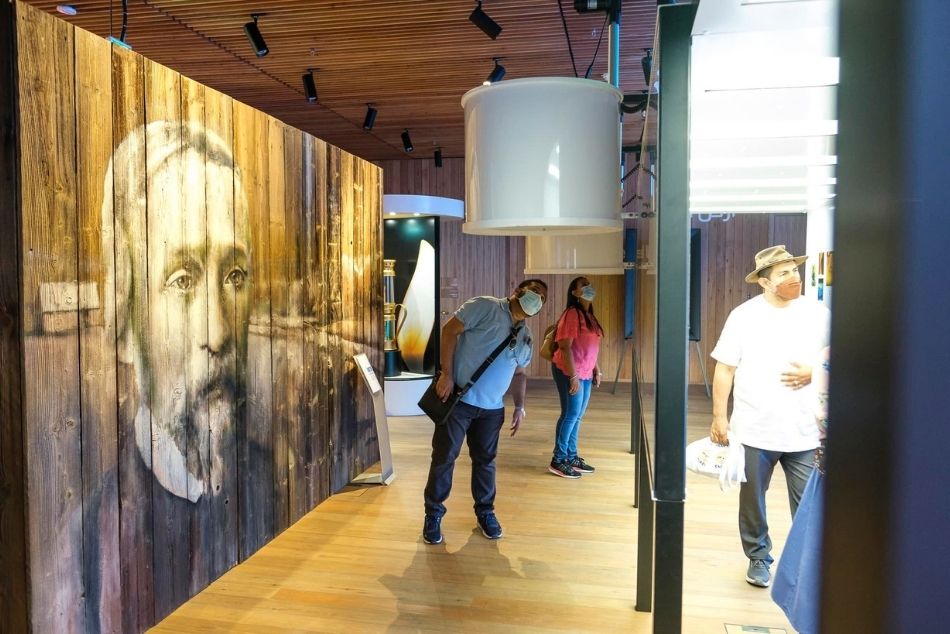 Drewniany deskal o wymiarach około 2 metry wysokości i 3 szerokości, obraz przedstawiający postać starszego mężczyzny z brodą. Obraz utrzymany w bieli i czerni.