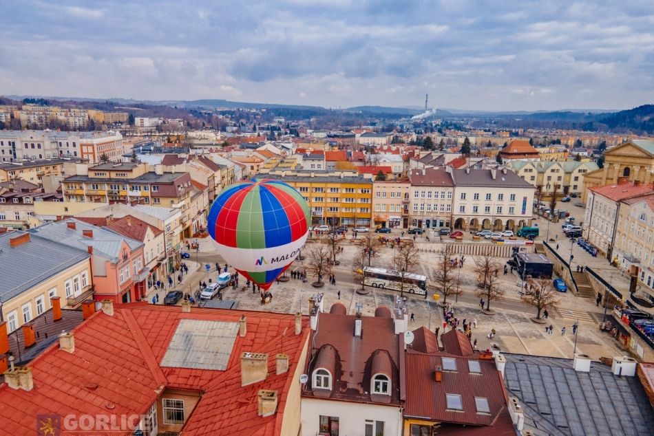 Panorama Rynku w Giorlicach z lotu ptaka. Na płycie rynku wielki balon z napisem Małopolska.