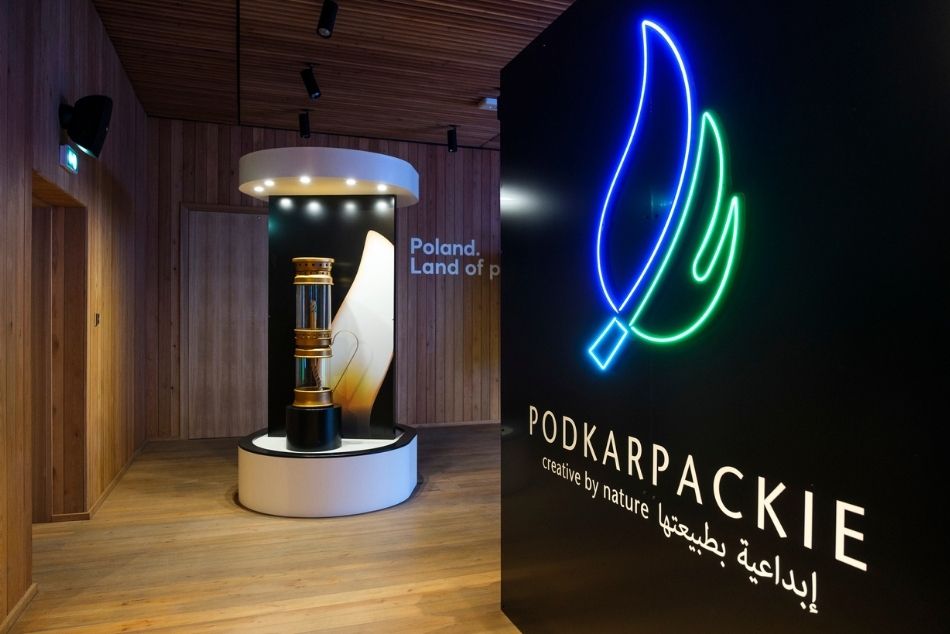 Podkarpackie na EXPO w Dubaju. Logo wystawy z napisem Podkarpackie z natury kreatywne. W tle okrągła gablota z dużą lampą naftową