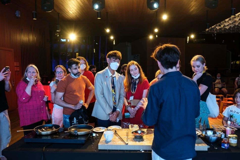 Młody kucharz opowiada zgromadzonej wokół kuchennego stołu publiczności o podkarpackiej kuchni.