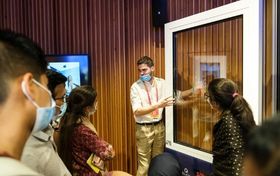Mężczyzna tłumaczy grupie osób działanie wynalazku firmy ML System - Smart Glass.