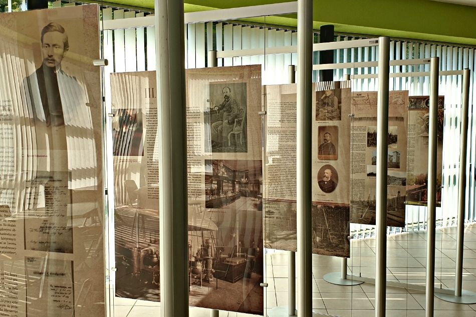 Plansze z wystawą o Ignacym Łukasiwiczu ustawione w budynku Muzeum. W tle rolety pionowe i okna.