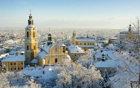Panorama starego miasta zimą. Ponad dachami kościelne wieże.