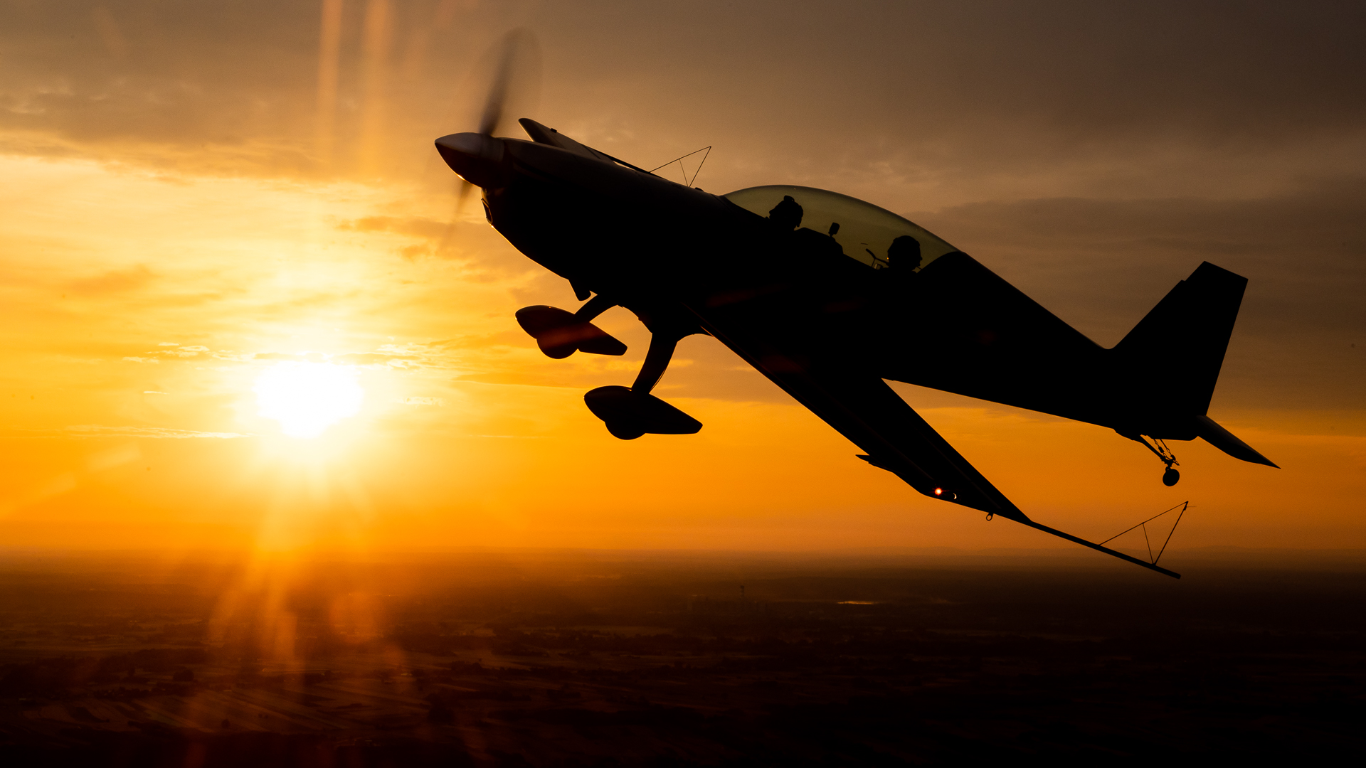 Samolot Extra 300L w locie w blasku zachodzącego słońca